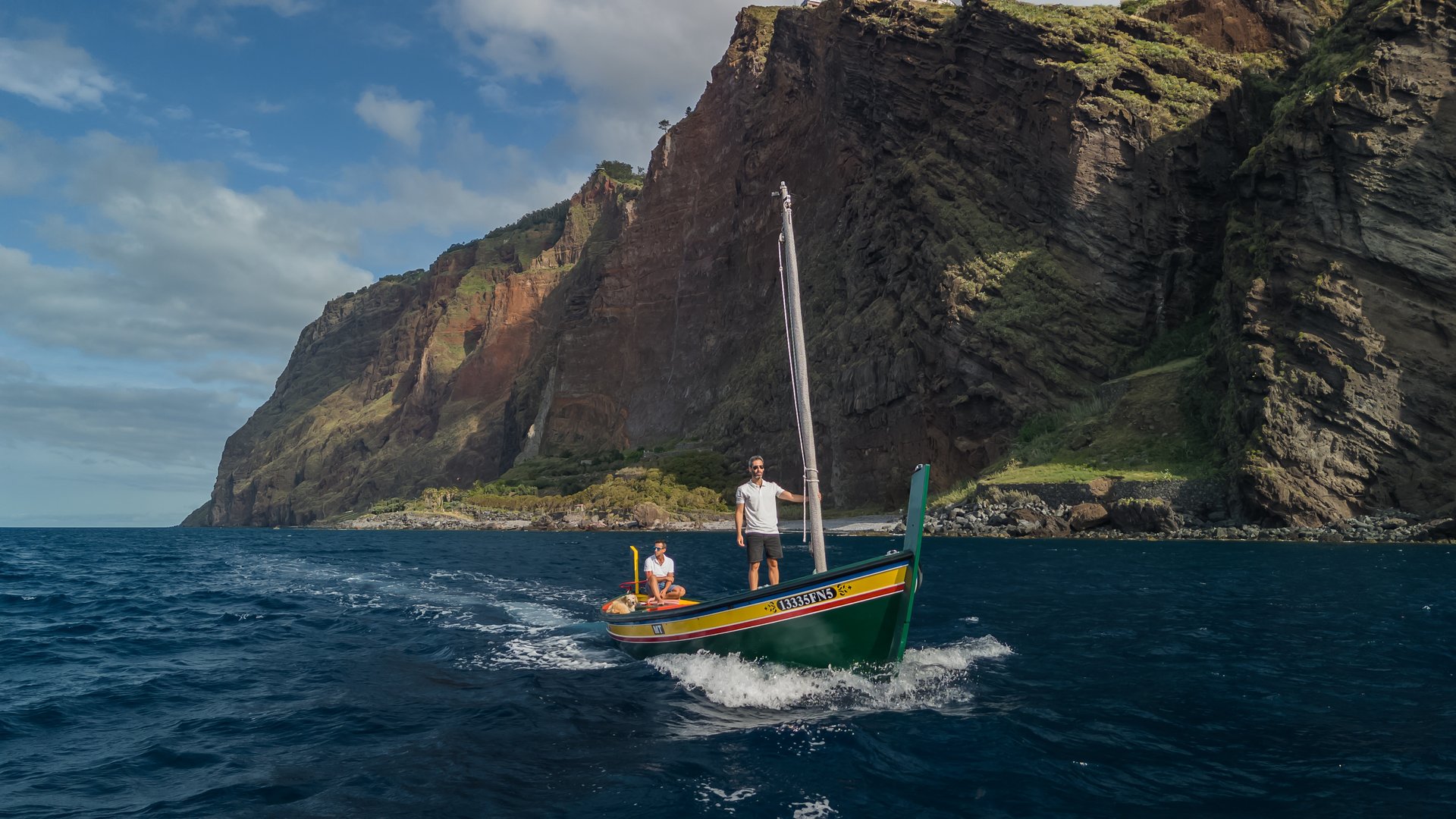 The Xavelha sailing beneath Madeira’s volcanic cliffs