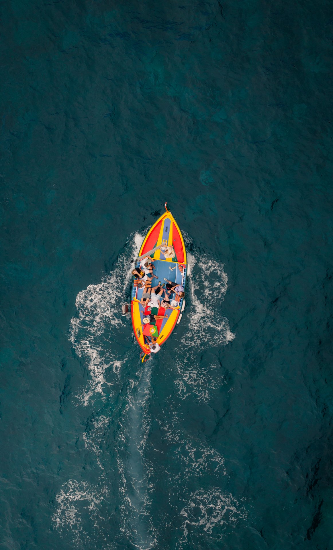 Top-down view of the colorful Xavelha on dark water
